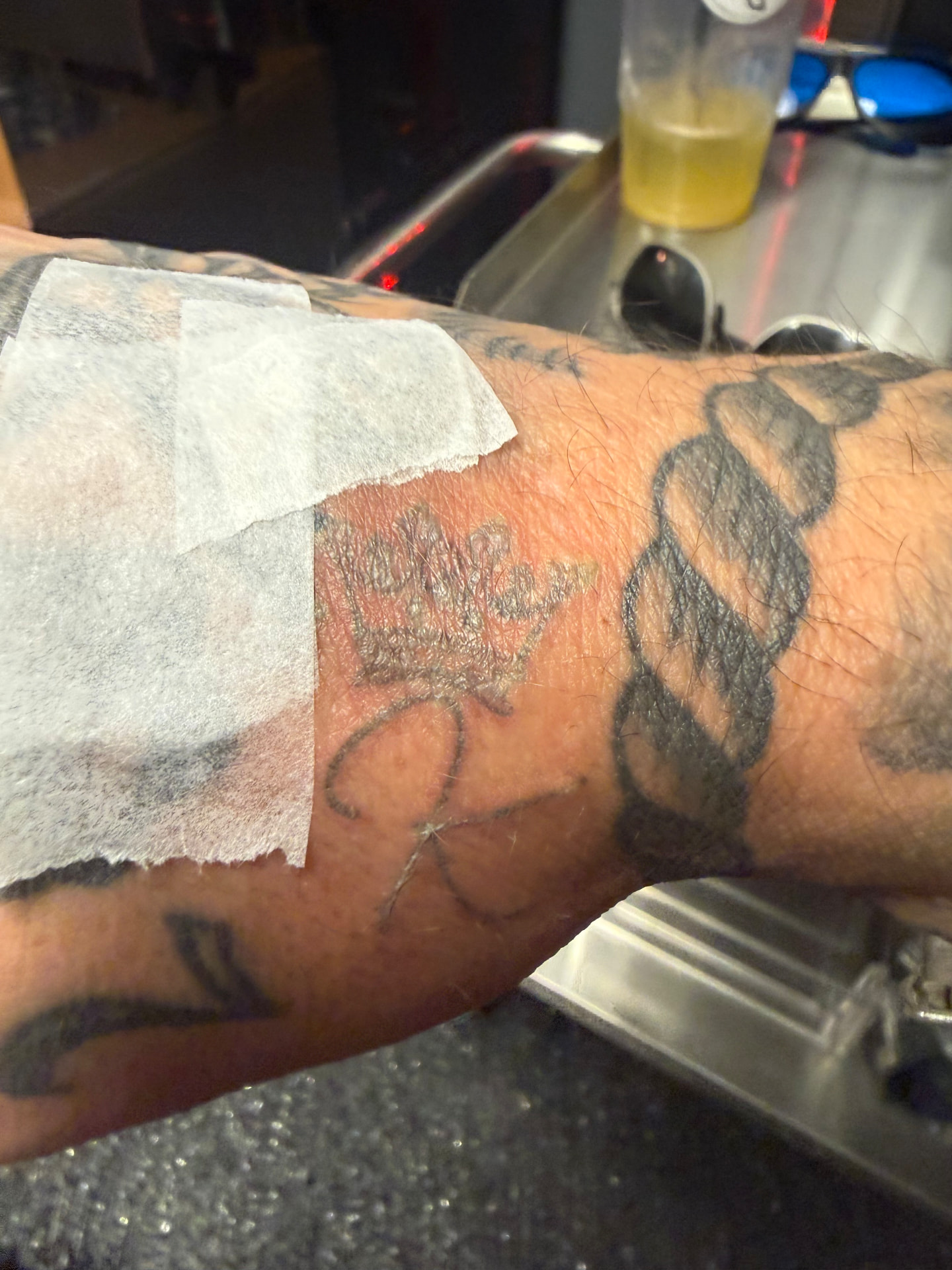 Forearm script tattoo fading after a laser session
