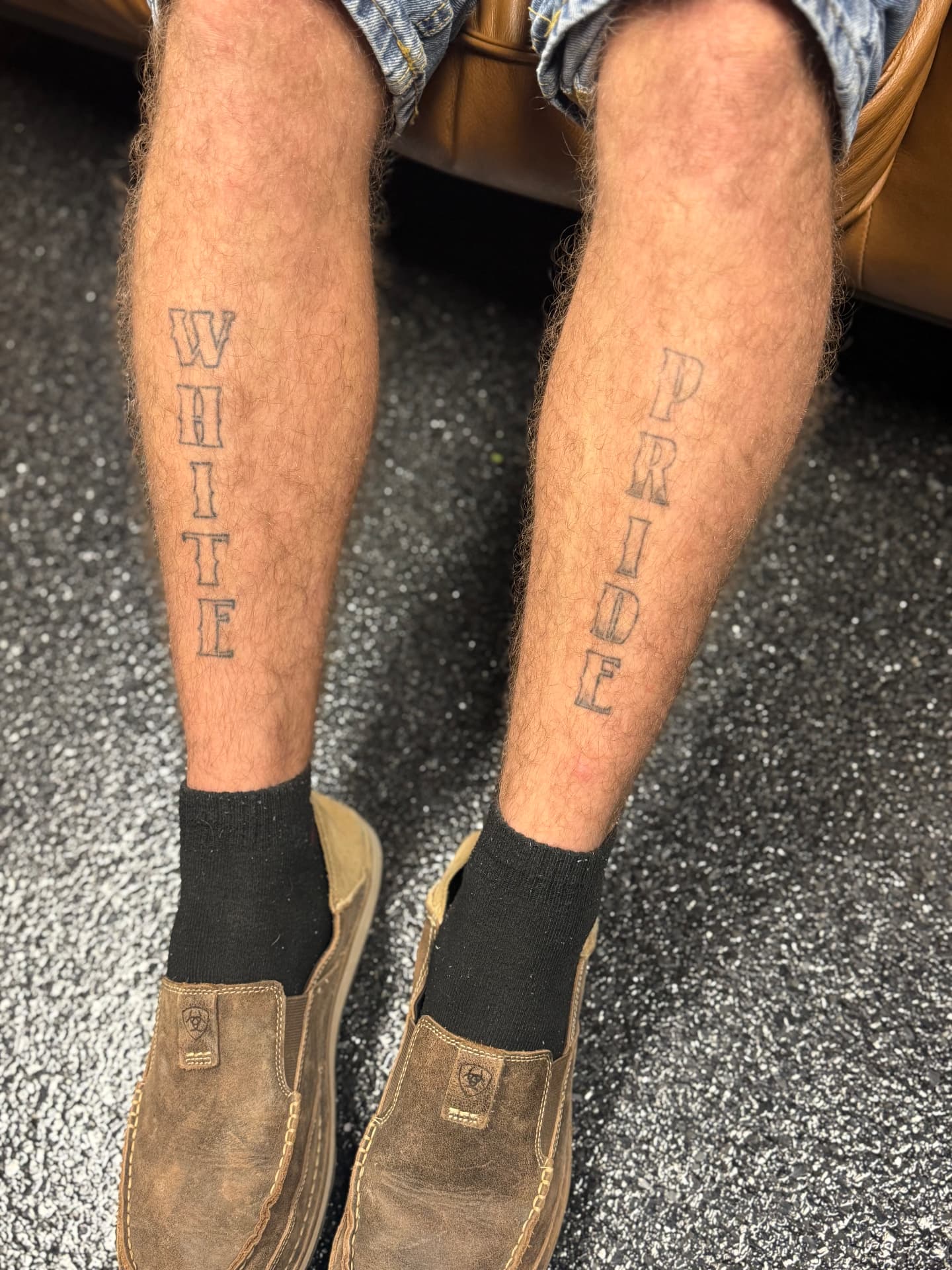 Faded lettering tattoos on both calves before laser treatment